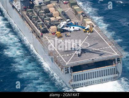 Un elicottero US Navy Airbus EC225 LP Super Puma rilascia forniture di carichi secchi e munizioni dalla USNS Wally Schirra, sul ponte della nave portuale Harpers Ferry-class USS Pearl Harbor () un rifornimento in mare con la nave d'assalto anfibio di classe Wasp USS Essex settembre 18, 2021 nel Mare Arabico. Foto Stock