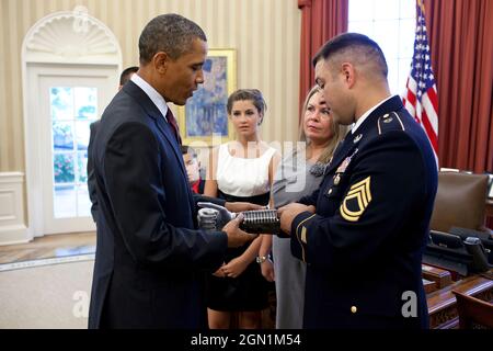 Sergente prima classe Leroy Arthur Petry, l'esercito degli Stati Uniti, mostra al presidente Barack Obama una targa con i nomi dei Rangers caduti dal 75° reggimento sul suo braccio protesico, durante un incontro nell'ufficio ovale, 12 luglio 2011. Il Presidente ha poi assegnato a SFC Petry la Medaglia d'onore per le sue coraggiose azioni durante le operazioni di combattimento contro un nemico armato a Paktya, Afghanistan, nel maggio 2008. (Foto ufficiale della Casa Bianca di Pete Souza) questa fotografia ufficiale della Casa Bianca è resa disponibile solo per la pubblicazione da parte delle organizzazioni di notizie e/o per uso personale la stampa dal soggetto(i) del p Foto Stock