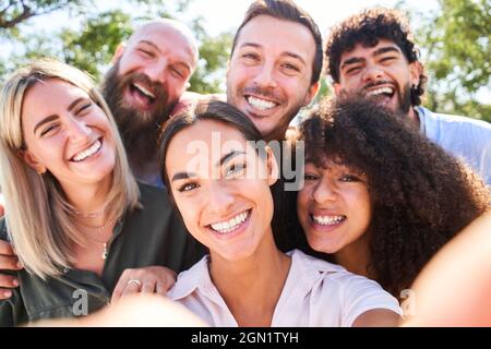 Gente multirazziale che prende selfie all'aperto - concetto di stile di vita felice con i giovani amici sorridenti che si divertono insieme. Foto Stock