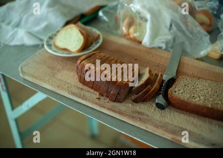 Pane di segale affettato nella sala da pranzo. Cibo per il pranzo. Affettatrice di pane in cucina. Foto Stock