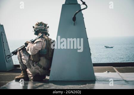 STRETTO DI HORMUZ (SETTEMBRE 17, 2021) corpo marino CPL. Kole Johnstone, un mitragliere assegnato alla Light Armored Reconnaissance Company, Battalion Landing Team 1/1, 11th Marine Expeditionary Unit (MEU), mantiene sotto controllo un contatto superficiale nelle vicinanze mentre transita lo stretto di Hormuz a bordo del molo di trasporto anfibio USS Portland (LPD 27). Portland e l'undicesima unità Marine Expeditionary sono dislocate nell'area della 5th Fleet degli Stati Uniti a sostegno delle operazioni navali per garantire la stabilità e la sicurezza marittima nella regione centrale, collegando il Mediterraneo e il Pacifico attraverso l'Occidente Foto Stock