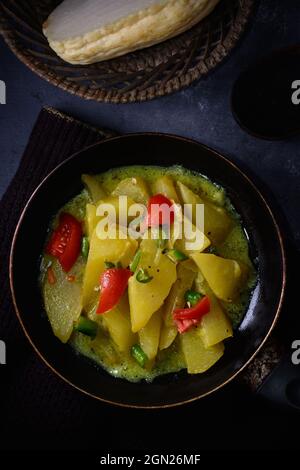 chayote cotto o piatto di chow con pomodori e peperoncini verdi su una padella, verdure di chayote affettate visibili sullo sfondo Foto Stock