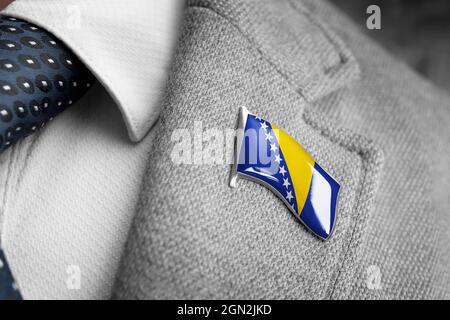 Distintivo di metallo con la bandiera della Bosnia-Erzegovina su un lapel tuta Foto Stock