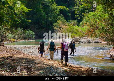 Un gruppo di escursionisti attraversa un fiume lungo il vecchio sentiero Camino Real, il parco nazionale di Chagres, Repubblica di Panama, America Centrale. Foto Stock