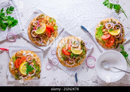 Carne di gyros greco con pita pane piatto, verdure e cipolle e Tzatziki tuffo su sfondo bianco Foto Stock