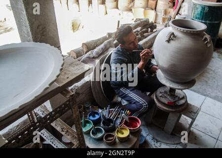 Cibuntu, Indonesia, 22/09/2021, Un artigiano disegna un fiore su un vaso di ceramica in Mekarbakti Village.vasi di ceramica da qui sono stati venduti a varie regioni in Indonesia come l'isola di Bali e sono stati venduti a paesi stranieri come gli Stati Uniti e l'Africa. I prodotti ceramici dall'Indonesia hanno varie forme che variano da caraffe di ceramica, decorazioni a forma di pesce, grandi vasi, statue di ceramica, piatti, bicchieri, a pagode. La gamma di prezzi dipende dalla dimensione e dal livello di complessità; il prezzo per un metro di vaso di ceramica alto è IDR 900,000 ($63.00). Foto Stock