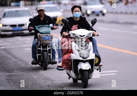 Shenyang, Shenyang, Cina. 22 settembre 2021. Il 22 settembre 2021, colpito dalle piogge, la temperatura a Shenyang è calata improvvisamente, con la temperatura più bassa che raggiunge circa 10Ã‚Â°C. Il raffreddamento ha portato molti cambiamenti ai cittadini, che hanno cambiato i loro vestiti uno dopo l'altro, e alcuni hanno persino indossato abiti invernali come i vestiti imbottiti di cotone. (Credit Image: © SIPA Asia via ZUMA Press Wire) Foto Stock