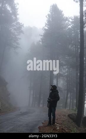 Bandipora, Jammu e Kashmir, India. 21 settembre 2021. Un uomo che fa clic sulle immagini dell'autostrada che collega Srinagar a Gilgit Baltistan nel distretto di Bandipora il 21 settembre 2021. Il Passo di Razdan è l'unico Passo ad alta quota tra Srinagar e Gurez, a un'altezza di 11,672 metri sopra il livello del mare. La strada sopra il passo, chiamata Bandipora-Gurez autostrada, collega diversi villaggi remoti, tra cui quelli vicino alla LOC con Bandipora e Srinagar. Credit: Adil Abbas/ZUMA Wire/Alamy Live News Foto Stock