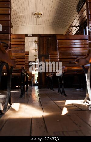 Vecchio carro in legno con sedili vuoti con alcune vecchie valigie in cima. Foto Stock