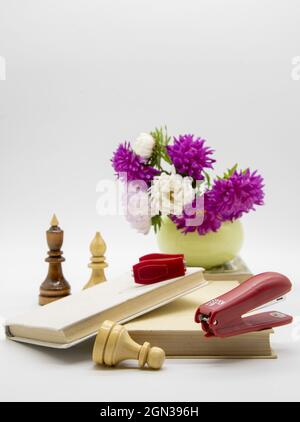 Una composizione di fiori in vaso, libri e vari accessori didattici su sfondo chiaro. Congratulazioni per la giornata dell'insegnante. Foto Stock