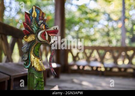 Scultura di drago con ornamento su piedistallo in costruzione invecchiata di bambù a Bali Indonesia Foto Stock