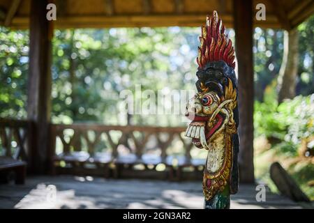 Scultura di drago con ornamento su piedistallo in costruzione invecchiata di bambù a Bali Indonesia Foto Stock