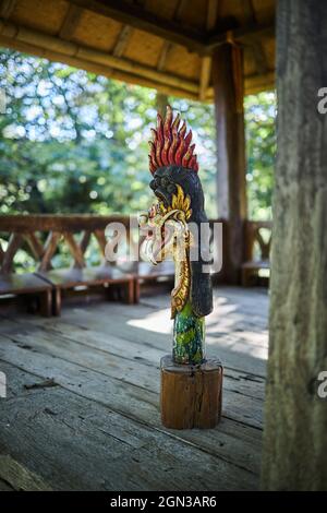 Scultura di drago con ornamento su piedistallo in costruzione invecchiata di bambù a Bali Indonesia Foto Stock