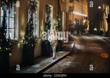 Una bambina cammina per la città di Vilnius in inverno. Foto Stock