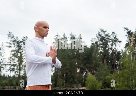 buddista in felpa bianca che prega nella foresta Foto Stock