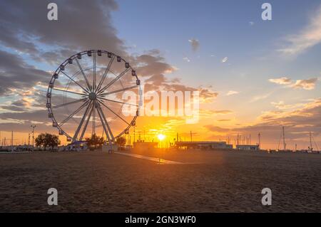 22.09.21 Rimini, Italia. Tramonto sulla ruota ferris nel porto di Rimini, cielo limpido. Foto Stock