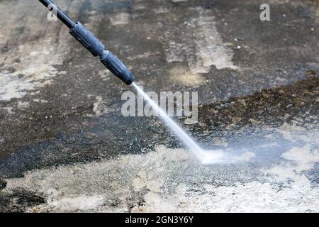 Pulizia del pavimento all'aperto con getto d'acqua ad alta pressione. Foto Stock