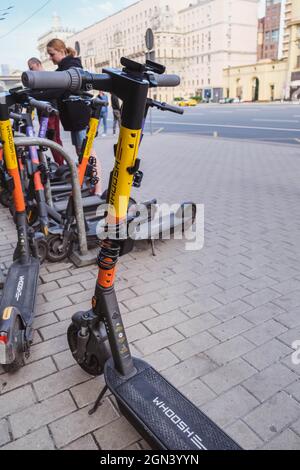 MOSCA, RUSSIA - Luglio 2021 . Parcheggio per biciclette e scooter elettrici a noleggio nel centro di Mosca. Foto verticale Foto Stock