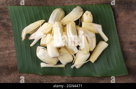 polpa di jackfruit crudo unmature su foglia di banana, frutta tropicale matura su una superficie di legno fondo, vista closeup preso dall'alto Foto Stock