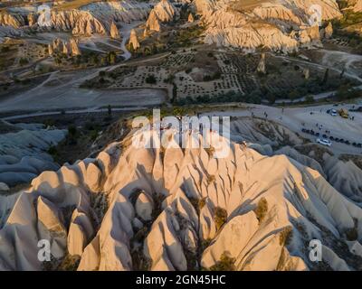 I turisti si godono il bellissimo tramonto vicino ai camini delle fate in Cappadocia, Turchia Foto Stock