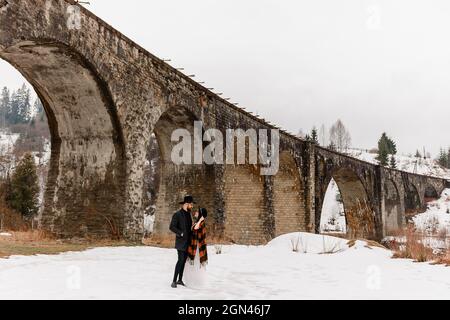 Vorokhta, Ucraina 31 marzo 2021: Sposi e sposi su un ponte, viadotto in Ucraina, luoghi turistici. Foto Stock