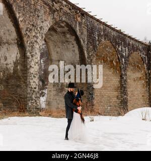 Vorokhta, Ucraina 31 marzo 2021: Sposi e sposi su un ponte, viadotto in Ucraina, luoghi turistici. Foto Stock