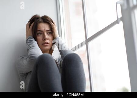 Disperata donna millenaria europea triste che soffre di depressione e problemi psicologici Foto Stock