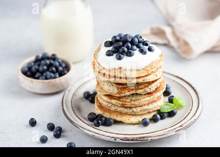 Pila di pancake di semi di papavero al limone con yogurt e mirtilli. Cibo sano per la colazione, pancake a basso contenuto di zucchero Foto Stock