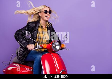 Bella motociclista donna con capelli ricci che indossa casco moto