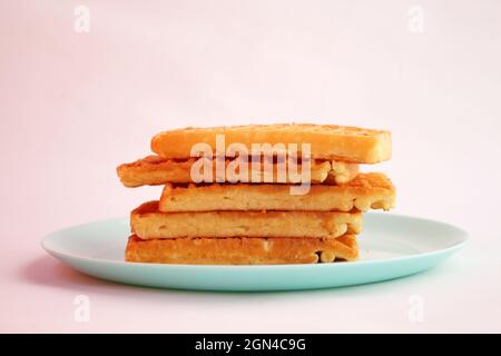 Waffle belgi con marmellata di albicocche su piatto turchese Foto Stock