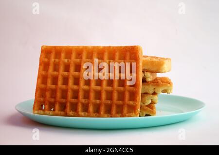 Waffle belgi con marmellata di albicocche su piatto turchese Foto Stock