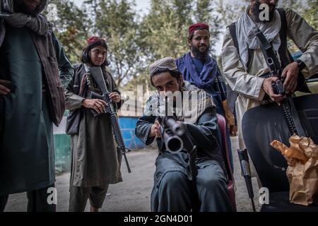 22 settembre 2021, Afghanistan, Kabul: Un giovane combattente talebano si stola intorno con il suo fucile mentre guarde fuori da un posto di polizia a Kabul. Foto: Oliver Weiken/dpa Foto Stock