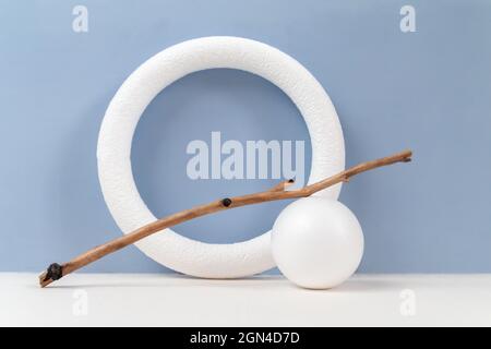 Cerchio con bastone di legno e palla su sfondo blu chiaro Foto Stock