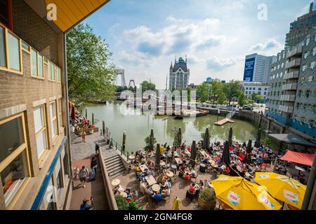 Rotterdam Olanda - Agosto 22 2021; persone che cenano sotto sul ponte sul lungomare nel Porto Vecchio con vista sugli edifici circostanti e baia con la nebbia Foto Stock