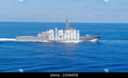 Japan Maritime Self-Defense Force marinai a bordo del cacciatorpediniere missilistico guidato di classe Kongo JS Chokai, man the Rails in preparazione per una cerimonia d'onore con il portaerei USS Carl Vinson di classe Nimitz degli Stati Uniti durante le operazioni congiunte del 19 settembre 2021 nel Mare delle Filippine. Foto Stock