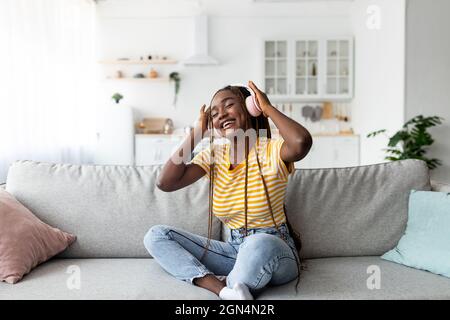 Bella donna afroamericana che ascolta musica Foto Stock