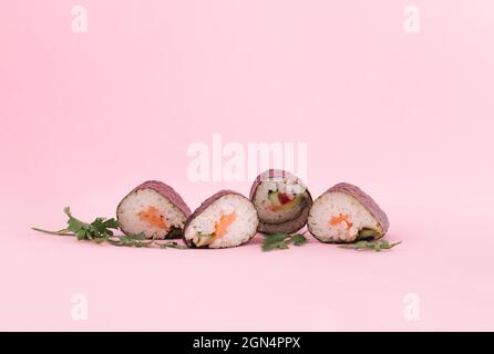 Concetto creativo minimo di cibo tradizionale su sfondo rosa pastello. Sushi. Un piatto a base di riso e pesce fresco. Foto Stock