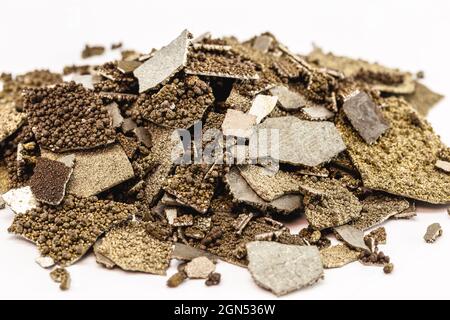 Campioni di manganese, metallo di manganese puro in fiocchi utilizzato nell'industria, fondo bianco isolato. Foto Stock