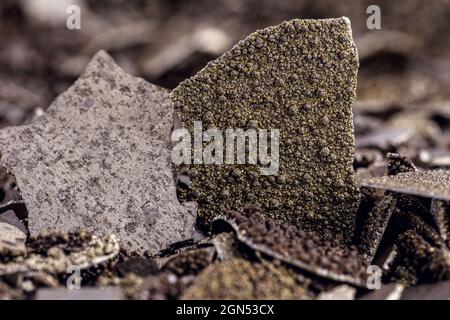 Campioni di manganese, metallo di manganese puro in fiocchi utilizzato nell'industria, fondo bianco isolato. Foto Stock