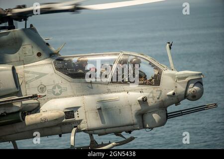 Oceano Pacifico, sul mare. 13 Agosto 2021. Un elicottero US Marine Corps AH-1Z Viper Attack, attaccato al Marine Medium Tiltrotor Squadron 165, si prepara a atterrare sul ponte di volo della nave d'assalto anfibio di classe Wasp USS Essex durante le operazioni di routine 13 agosto 2021 nell'Oceano Pacifico. Credito: CPL. Israele Chincio/Stati Uniti Marine Corps/Alamy Live News Foto Stock