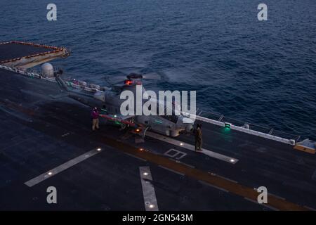 Oceano Pacifico, Stati Uniti. 18 maggio 2021. I marinai della Marina degli Stati Uniti rifornano un elicottero AH-1Z Viper Attack, attaccato al Marine Medium Tiltrotor Squadron 165, sul ponte di volo della nave d'assalto anfibio di classe Wasp USS Essex durante le operazioni notturne nell'Oceano Pacifico 18 marzo 2021 al largo della costa della California, USA. Credit: MC3 Brett McMinoway/U.S. Navy/Alamy Live News Foto Stock