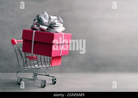 Carrello giocattolo supermercato con scatola regalo. Spazio di copia. Foto Stock