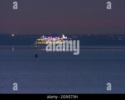 Sheerness, Kent, Regno Unito. 22 settembre 2021. La nave da crociera 'Disney Magic' vista illuminata di notte da Sheerness, Kent questa sera dopo la partenza dal Tamigi (Southend in mare sullo sfondo). Disney Magic attualmente sta operando un certo numero di crociere brevi di staycation (2-3 notti) intorno al Regno Unito. Credit: James Bell/Alamy Live News Foto Stock