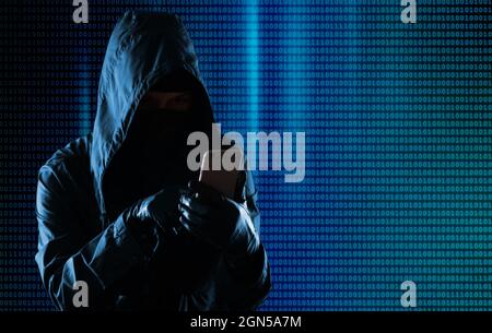 Hacker di cyber-criminalità Hooded usando il telefono cellulare internet hacking nel cyberspazio, concetto di sicurezza dei dati personali online Foto Stock