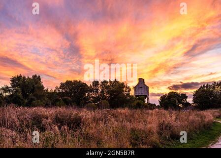 Royston, Barnsley, South Yorkshire, Regno Unito, 22 settembre 2021, Meteo. Formazioni di nubi illuminate al tramonto sul Rabbit Ings Country Park e i resti di Monckton Colliery dell'epoca delle miniere di carbone della Gran Bretagna. L'incantesimo caldo e secco continua nella stagione autunnale. Credit: Paul Biggins/Alamy Live News Foto Stock