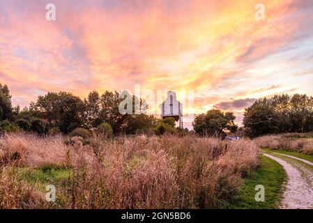 Royston, Barnsley, South Yorkshire, Regno Unito, 22 settembre 2021, Meteo. Formazioni di nubi illuminate al tramonto sul Rabbit Ings Country Park e i resti di Monckton Colliery dell'epoca delle miniere di carbone della Gran Bretagna. L'incantesimo caldo e secco continua nella stagione autunnale. Credit: Paul Biggins/Alamy Live News Foto Stock