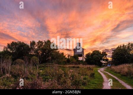 Royston, Barnsley, South Yorkshire, Regno Unito, 22 settembre 2021, Meteo. Formazioni di nubi illuminate al tramonto sul Rabbit Ings Country Park e i resti di Monckton Colliery dell'epoca delle miniere di carbone della Gran Bretagna. L'incantesimo caldo e secco continua nella stagione autunnale. Credit: Paul Biggins/Alamy Live News Foto Stock