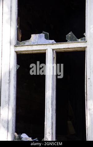 Finestra di casa abbandonata con vetro rotto. Foto Stock