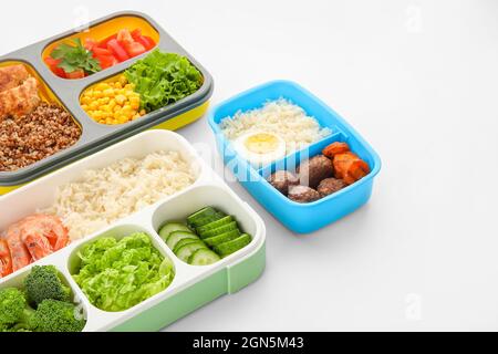 Contenitori con vari alimenti sani su sfondo bianco, primo piano Foto Stock