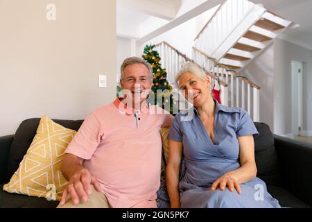 Felice coppia caucasica senior che hanno videochiamata, guardando la macchina fotografica a natale Foto Stock